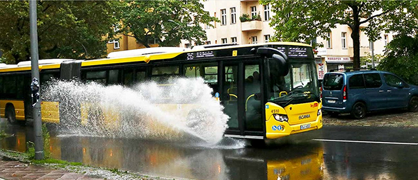 BVG-Bus fährt durch überflutete Straße bei Starkregen in Berlin